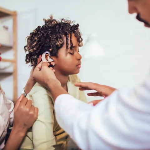 Child being fitted with a hearing aid.