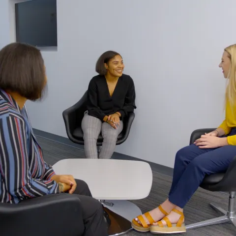 3 individuals sitting in chairs facing each other