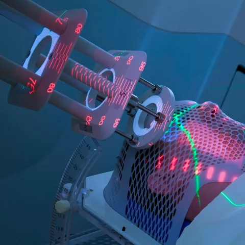 patient laying on table with medical imaging equipment directed at head
