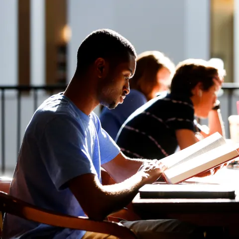 undergraduate student at library reading table