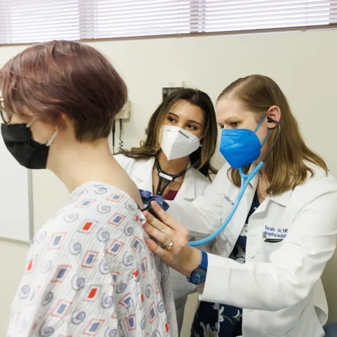 Two female doctors checking on a patient.
