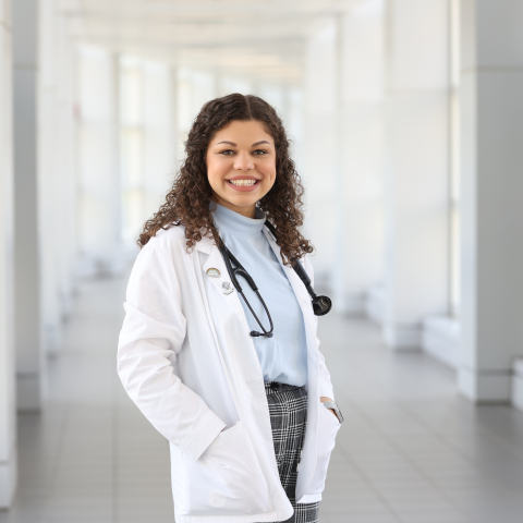medical student in a hallway with a white coat and stethoscope 