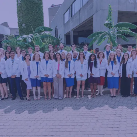 large group of students in white coats