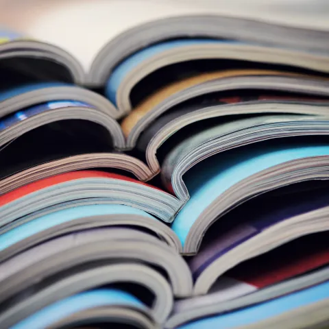 stack of magazines on a wooden table
