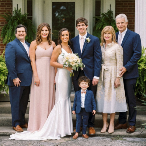 Zach Tarter on his wedding day standing next to his wife with both sets of parents on each side of them. 