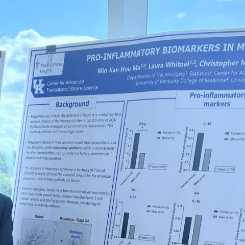 Justin Ma (BG M3) stands next to research poster