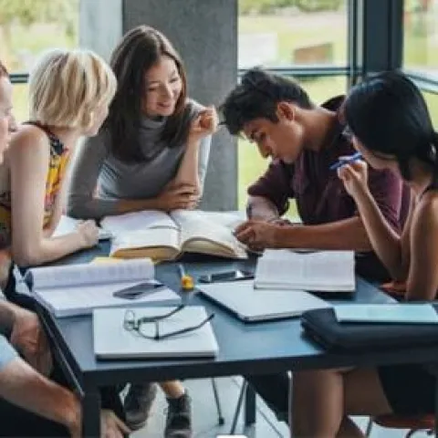 Group of people talking and writing around the table