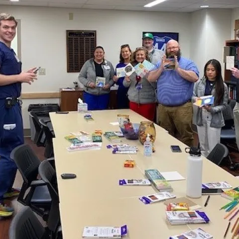 Group of staff members smiling and showing their colored tile from colors and connections