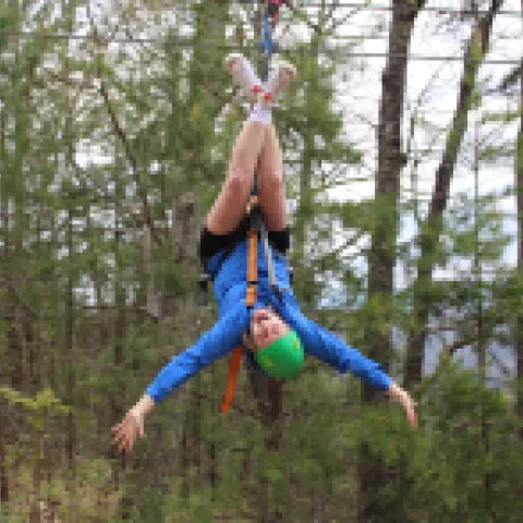 Person ziplining, hanging upside down