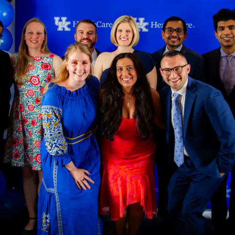 Pulmonary fellows grouped together in front of a branded wall.