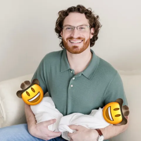 Dr. Henderson holds his newborn twin boys, whose faces are concealed with cowboy hat emojis