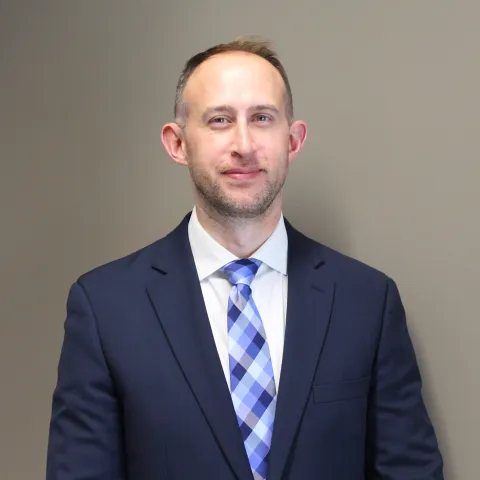 Andrew Gorton, 2026 graduate of the CT Surgery integrated residency, is dressed in blue blazer, plaid tie, and white shirt.