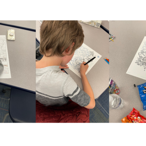 Three kids tracing comic drawings at a table.