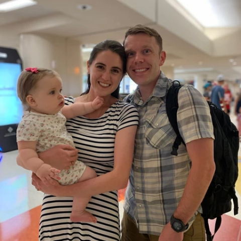 USAF Major, Dr. Chris Belcher at airport with partner and daughter