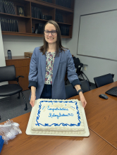 Dr. Bullens displays her congratulatory cake for defending her dissertation and earning her PhD