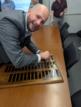 Alex Pettey adds his name to the plaque of graduates.