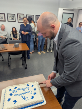 Dr. Pettey cuts the cake, celebrating his Ph.D. graduation.