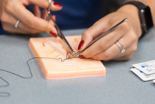 Close-up of hands working on suture