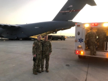 Dr. Chris Belcher handing off a patient to one of his colleagues on ground at airport