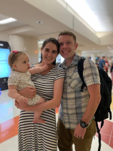 USAF Major, Dr. Chris Belcher at airport with partner and daughter