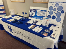 A long table is filled with informational material about colon and rectal cancer.