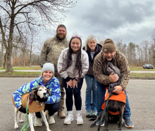 Megan Ward (front left) poses with family members and their dogs during an outdoor gathering. She credits the support of family and loved ones for helping her navigate the challenges of medical school.