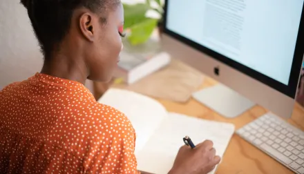 Woman working at a computer desk.