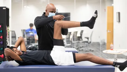 UK basketball player laying on an exam table in sports medicine research institute