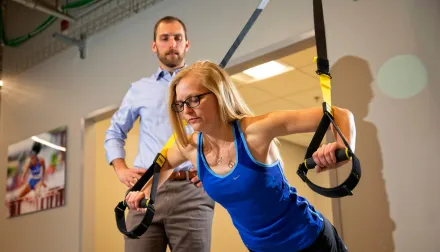 Sports Medicine patient and provider; patient using arm straps
