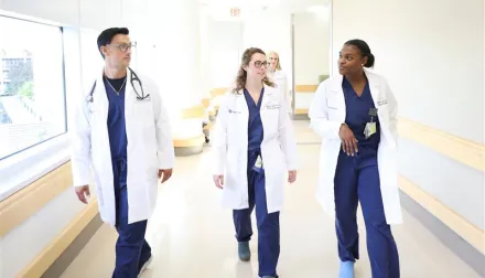 Graduate medical learner / residents walking down the hallways of UK hospital.