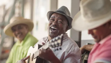 Elderly men playing instruments, enjoying each other's company and the music. 