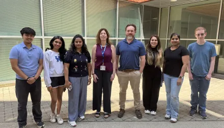 Eight lab members standing shoulder to shoulder