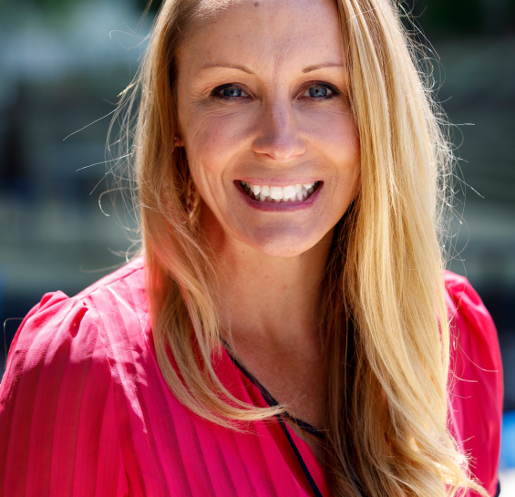 Dr. Ickes in a pink blouse outside in the sun