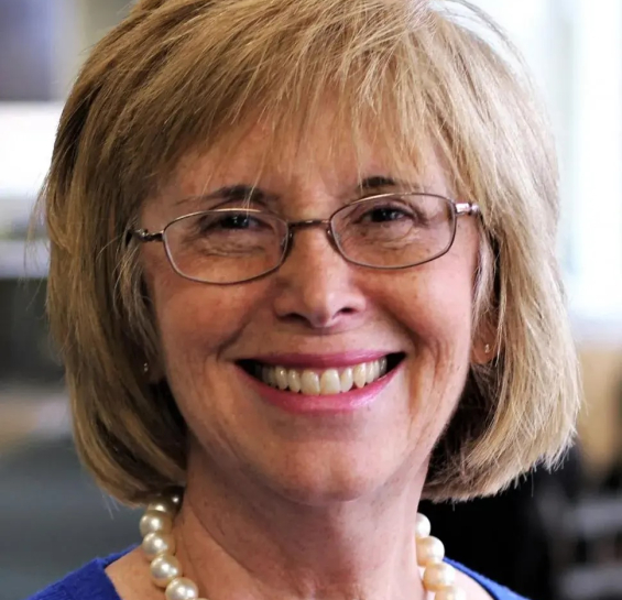 Dr. Hahn smiling at the camera in a blue shirt and pear necklace.