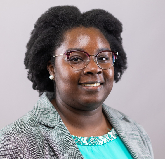 Woman in gray plaid blazer and green blouse with glasses
