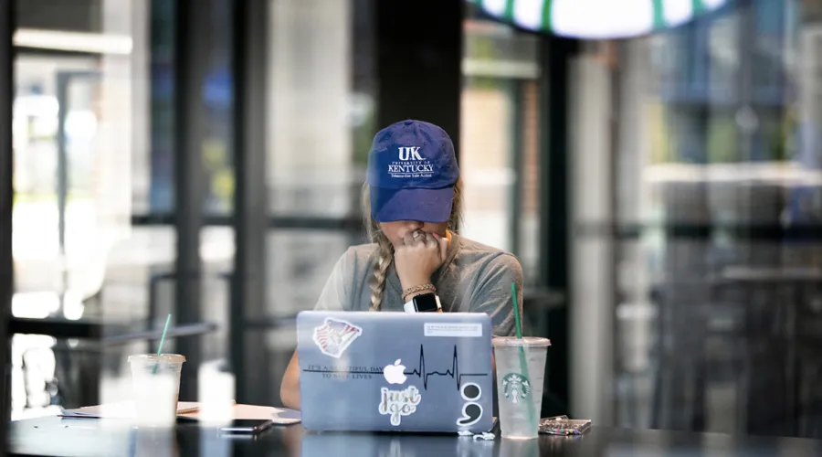 Girl working at laptop on campus.