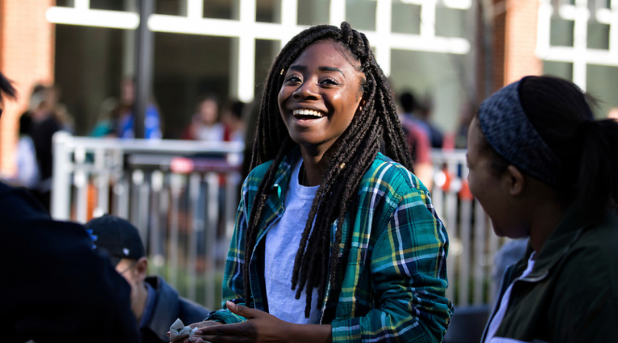 Female black student on campus, laughing.