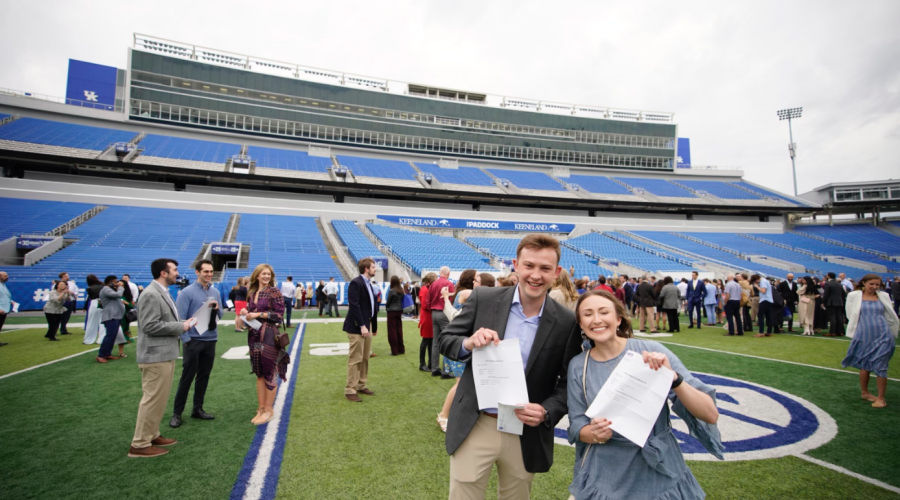 Students in Kroger Field hold up their Match letters