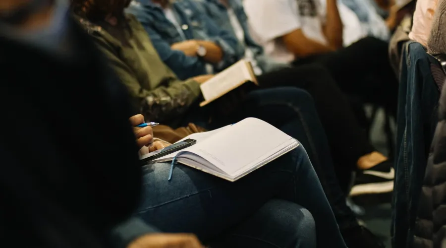 People sitting in chairs with journals in laps