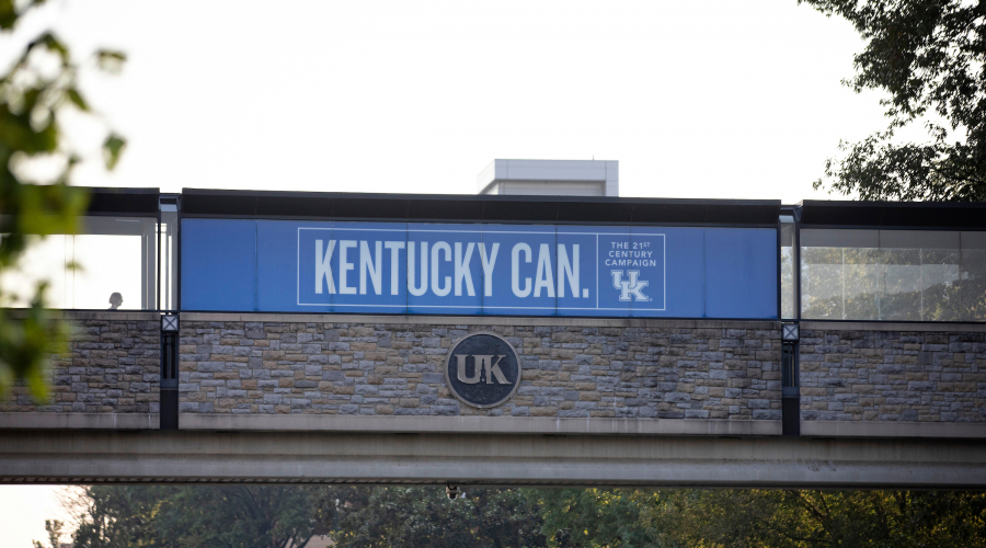 walkway above street with sign stating "Kentucky Can. The 21st Century Campaign." Also include UK logo.