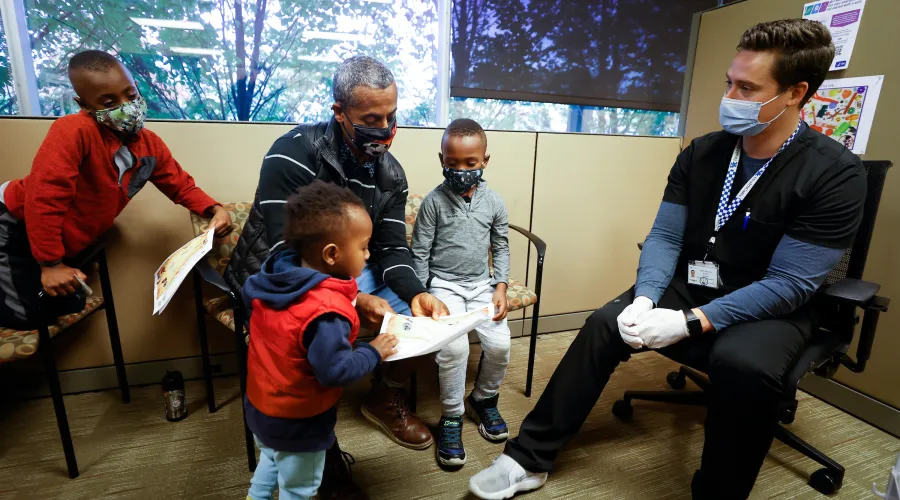 group of kids with a guardian and a provider in a doctor's office