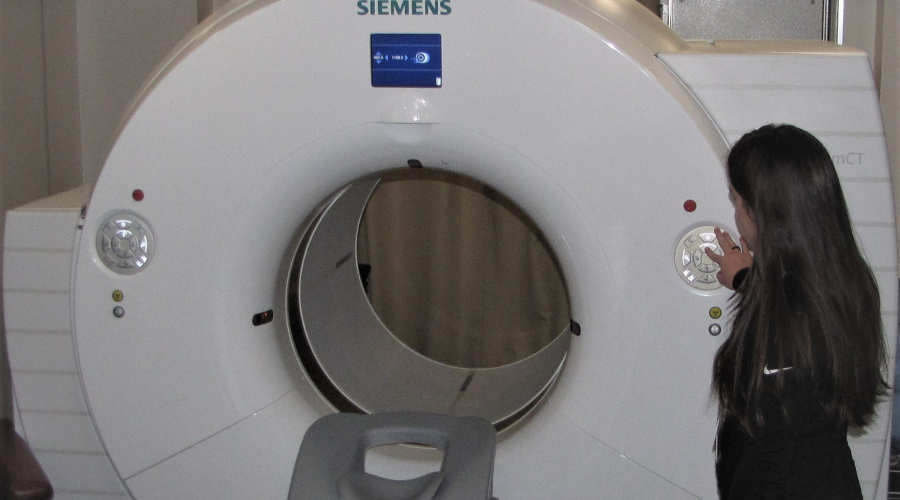 Positron Emission Tomography machine with provider standing to the side