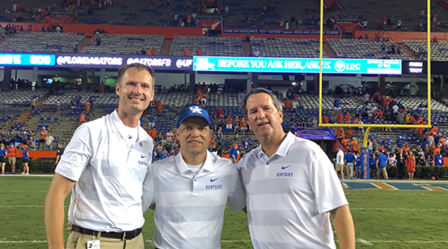 Three sports medicine faculty at a football game.