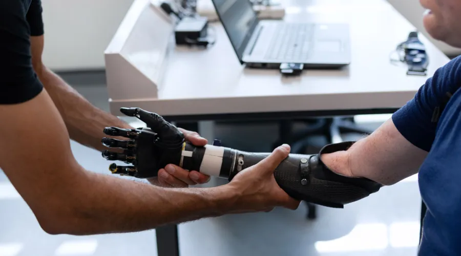 Doctor helping patient with prosthetic arm