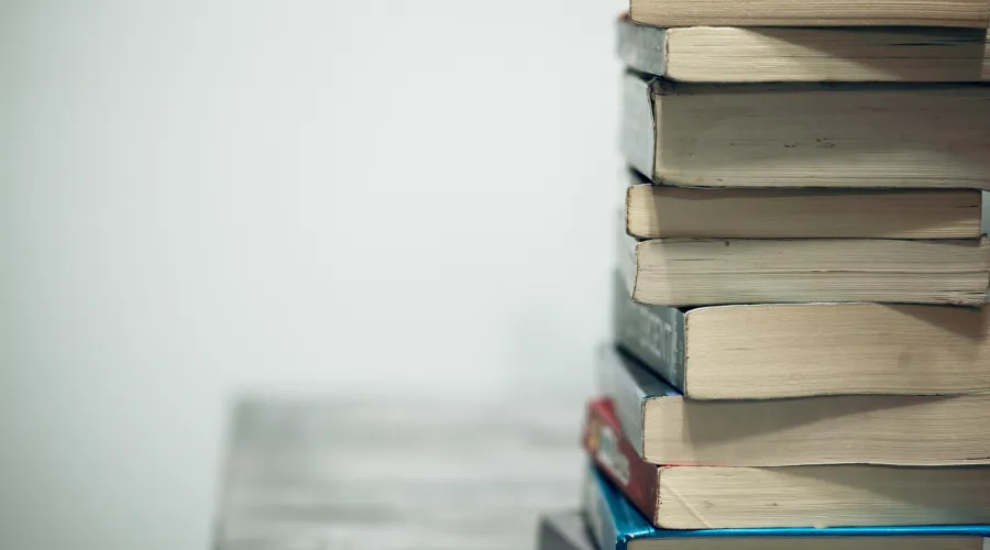 A stack of books sitting on a desk