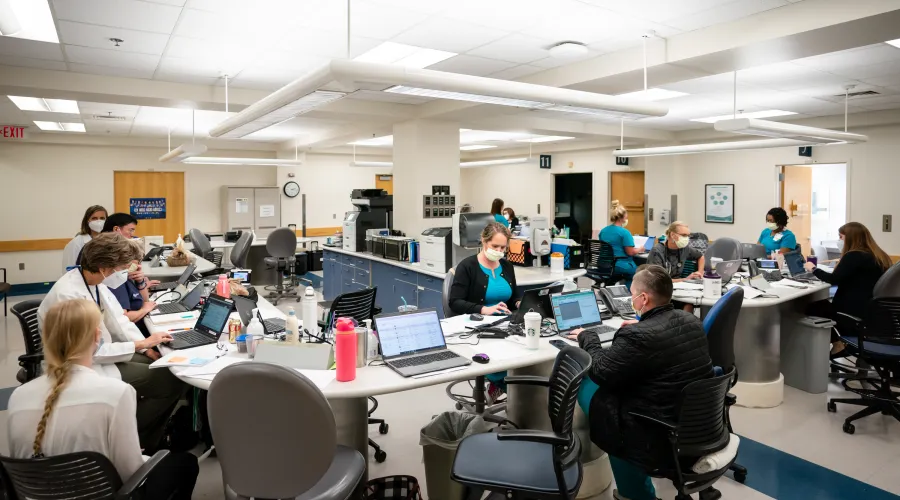 large room with medical providers -- doctors, nurses, support staff -- filling out paperwork and working on screens