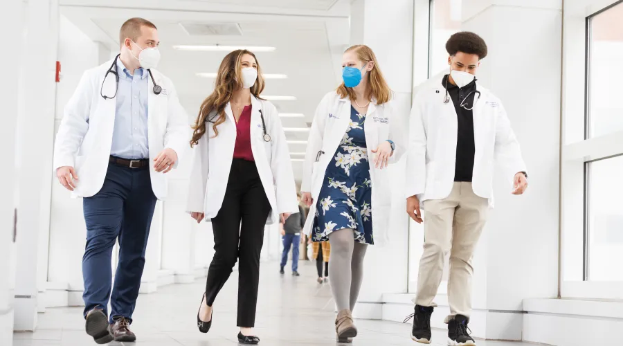 Students and a professor walking through a hallway