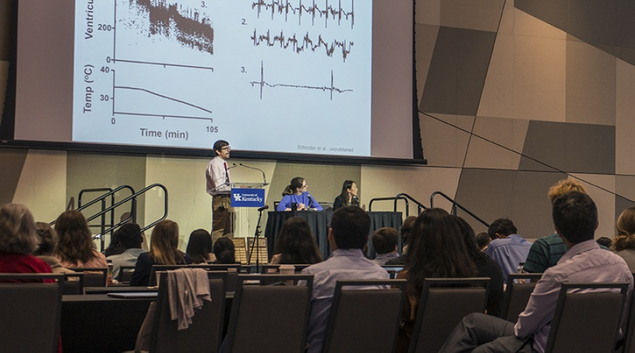 Researchers presenting to an audience during research day