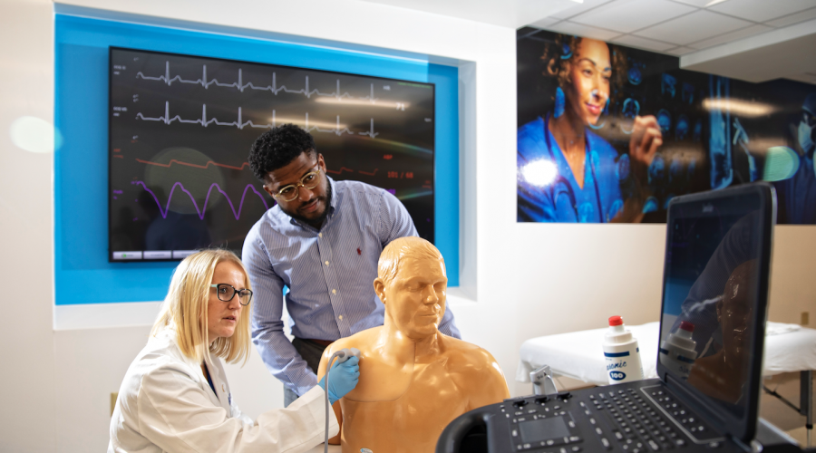 medical students using an ultrasound machine on medical dummy
