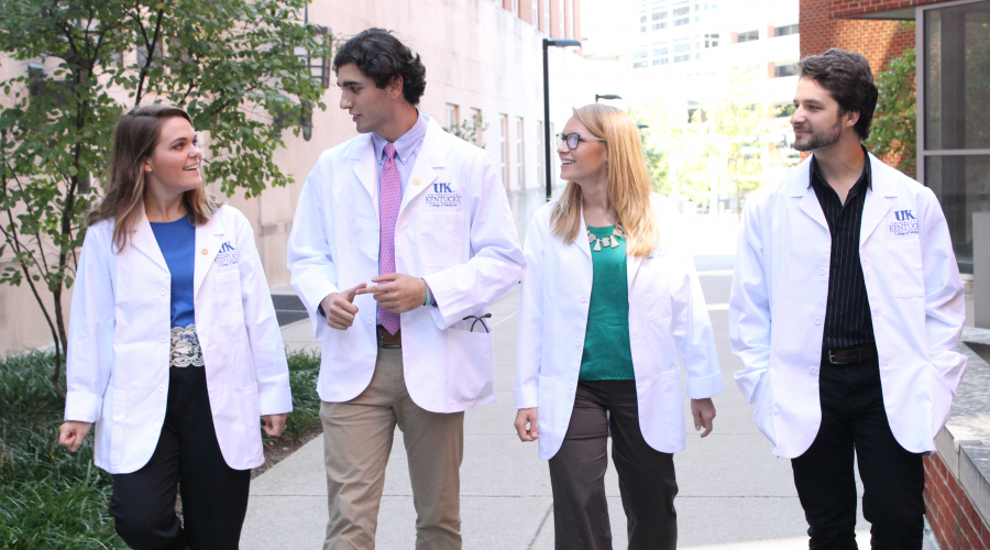group of medical students walking outside on sidewalk